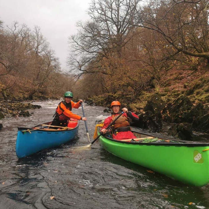 intermediate white water canoe with green wave guiding